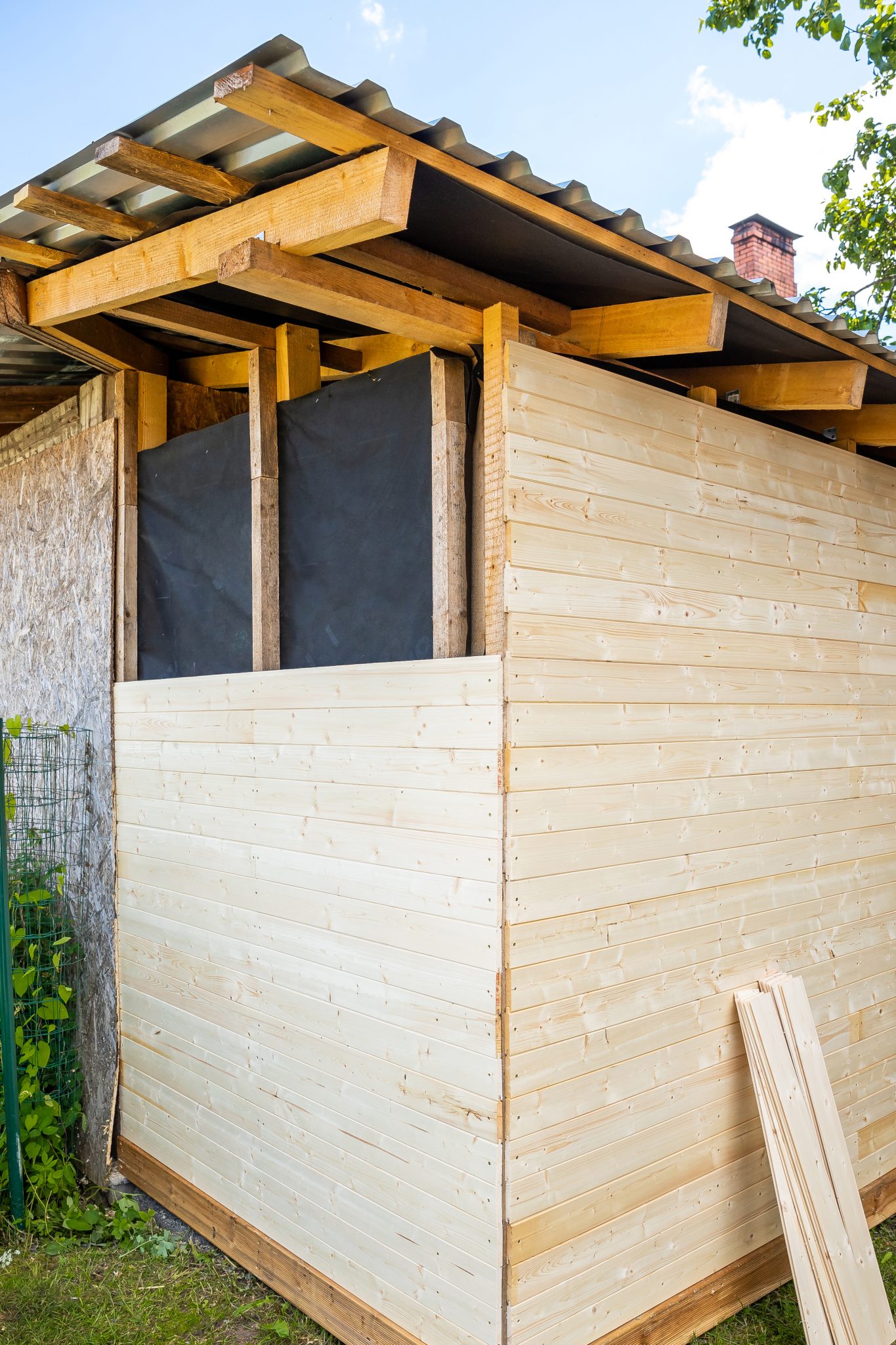 Vue extérieure d'un mur en bois partiellement construit avec une isolation exposée.