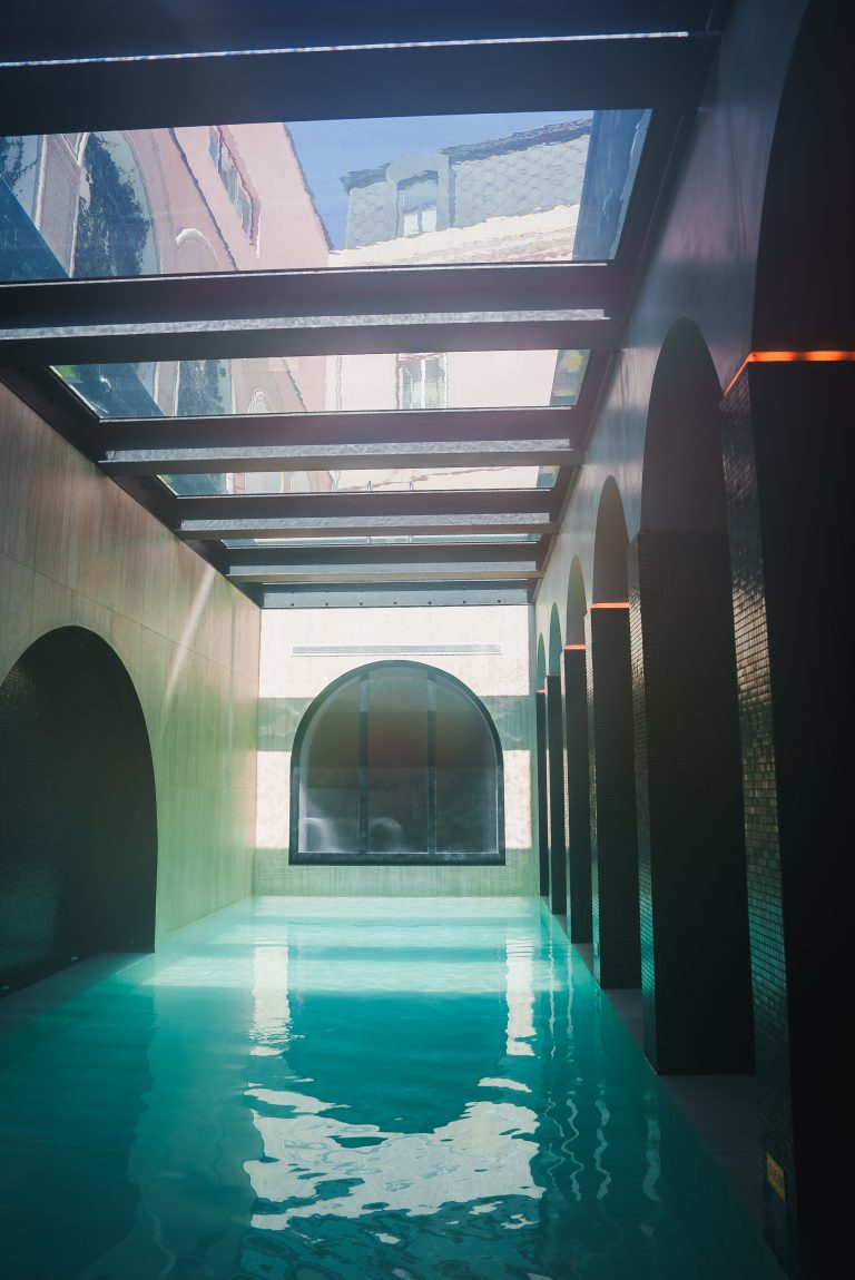 Piscine intérieure luxueuse avec des voûtes et un plafond en verre