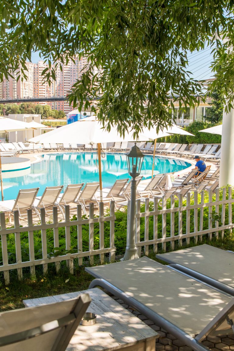 Chaises longues et parasols blancs au bord de la piscine dans un hôtel