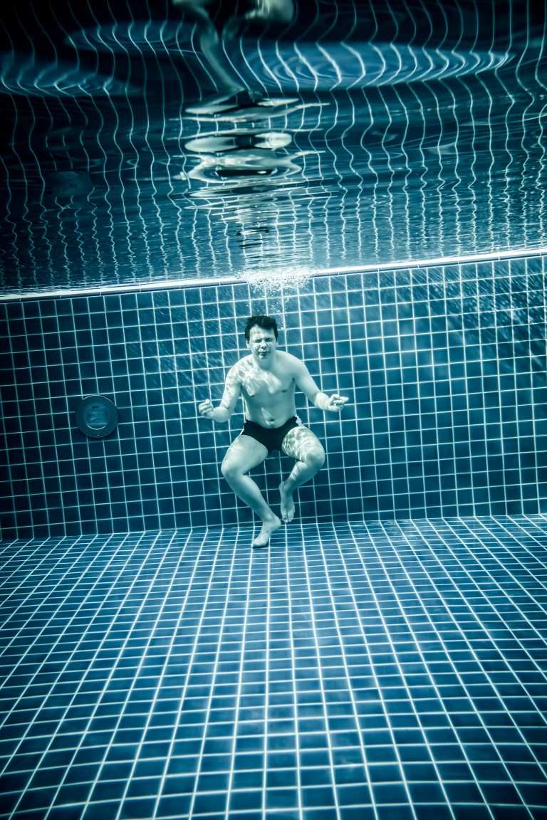 Des personnes debout dans une piscine, illustrant la profondeur de l'eau.